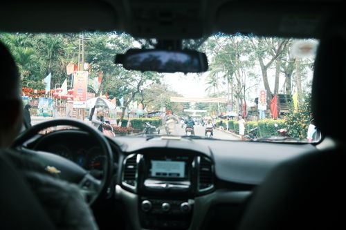 Free Street view from inside a car showcasing the bustling urban atmosphere with motorcycles and activity. Stock Photo