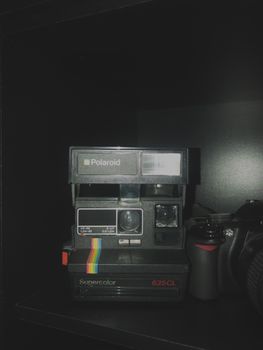 Close-up of a classic Polaroid Supercolor 635CL camera against a dark backdrop.