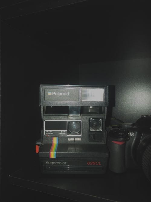 Free Close-up of a classic Polaroid Supercolor 635CL camera against a dark backdrop. Stock Photo