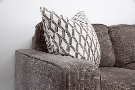 Stylish gray sofa with a patterned throw pillow adds elegance to any living space.