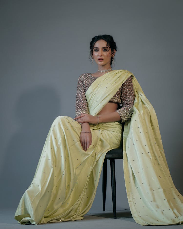 Woman In Yellow Dress Sitting On Black Chair