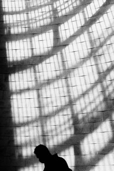 Black and white silhouette of a person with dramatic shadows in Lisbon.
