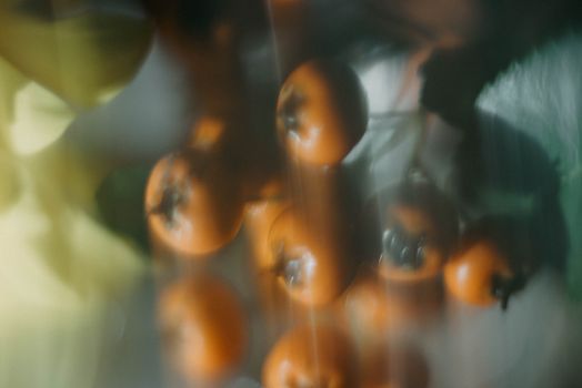 Artistic image of orange berries with blurred leaves and abstract effect.
