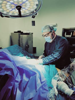 Focused surgeon in operating room performing surgery under bright surgical lights.
