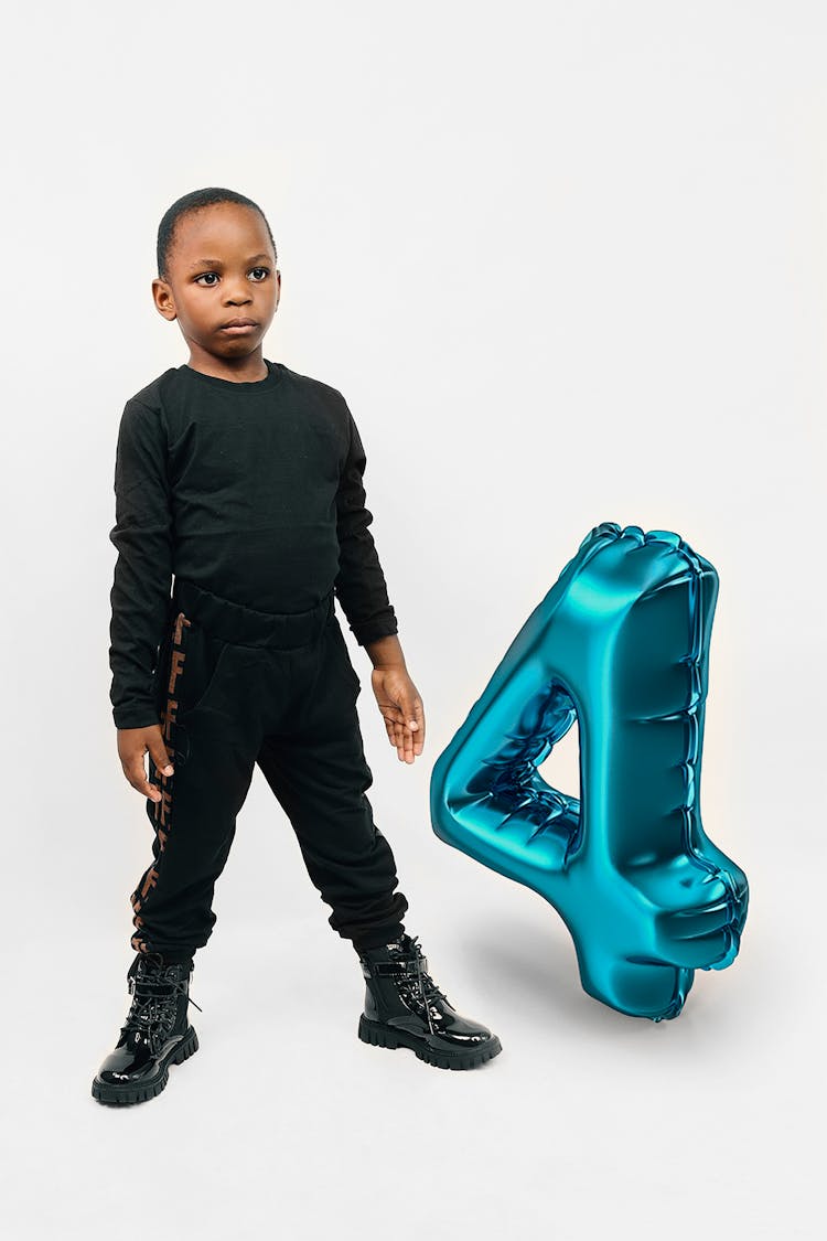 Boy With Balloon Posing In Studio