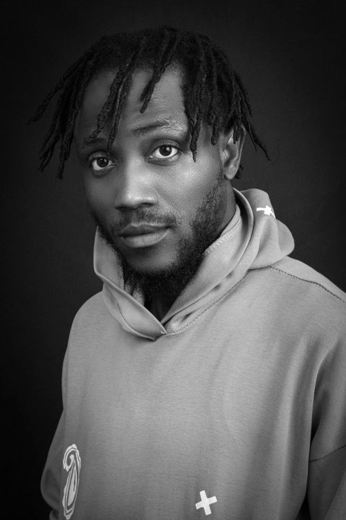 Free Black and white portrait of a man with dreadlocks wearing a hoodie, showcasing expressive emotion. Stock Photo