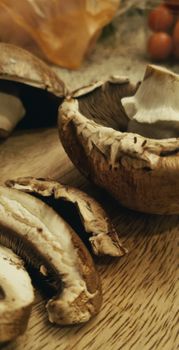 Close-up of sliced Portobello mushrooms ready for cooking on a rustic wooden board.
