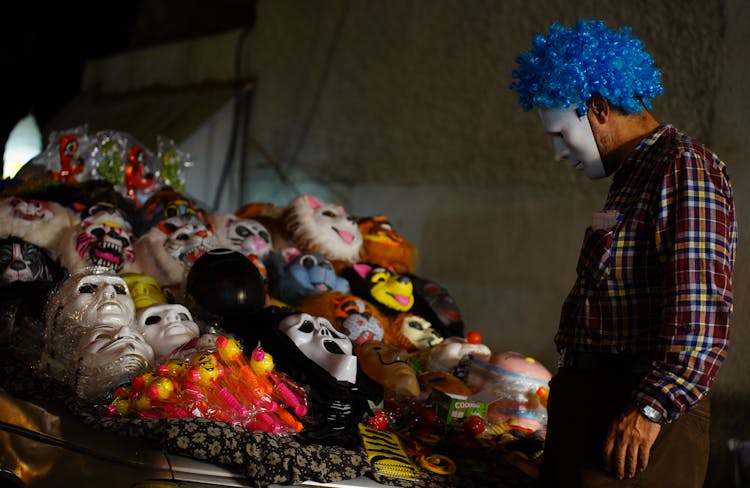 Scary Person Looking At The Pile Of Halloween Masks 