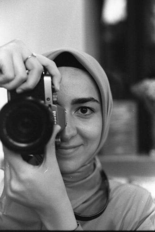 Black and White Photo of a Woman Taking a Picture with a Camera 
