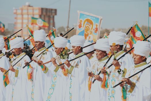 Ethiopian ritual in Addis Ababa with men in white gowns and turbans holding religious items.