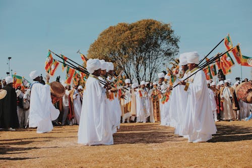 Men in Traditional Clothing Standing in Rows and Holding Flags