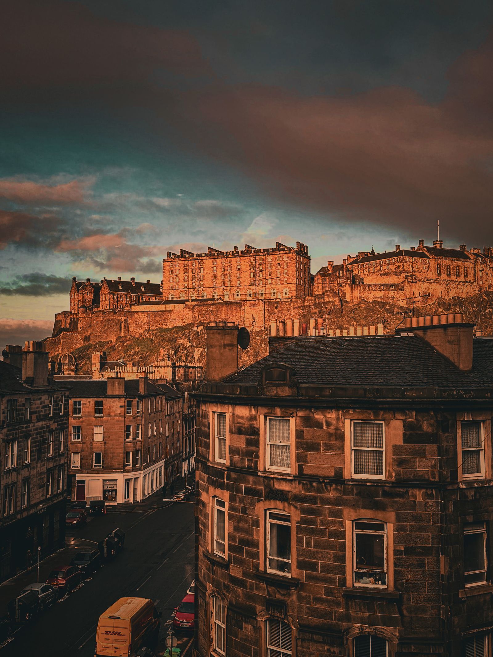 Edinburgh Castle on its hilltop above sandstone tenements at sunset