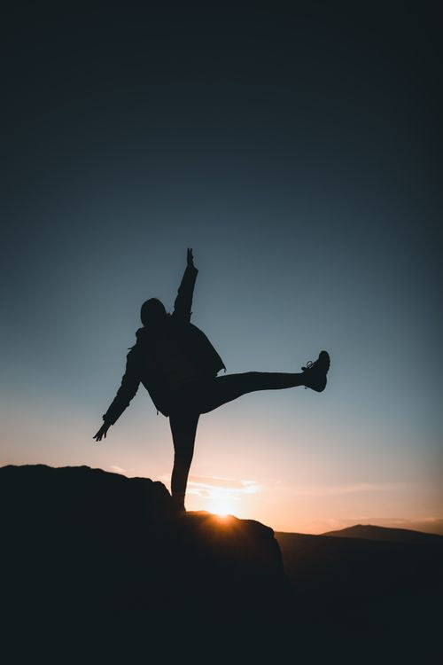 Free Silhouette of a person balancing on a rock during sunset in Ortahisar, Nevşehir, Türkiye. Stock Photo