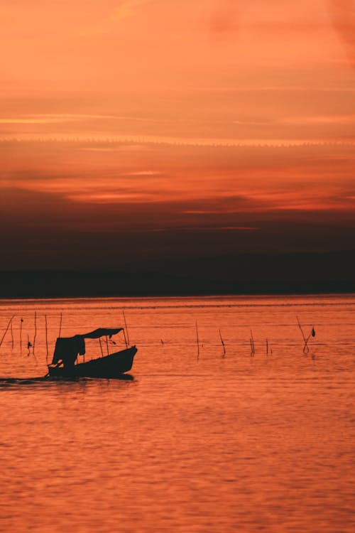 Silhouette of Boat on Body of Water 