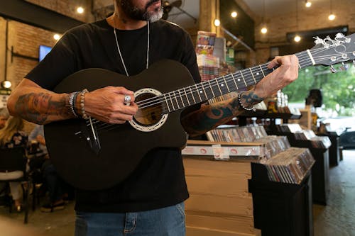 Close-up of Man Playing a Guitar in a Music Store 