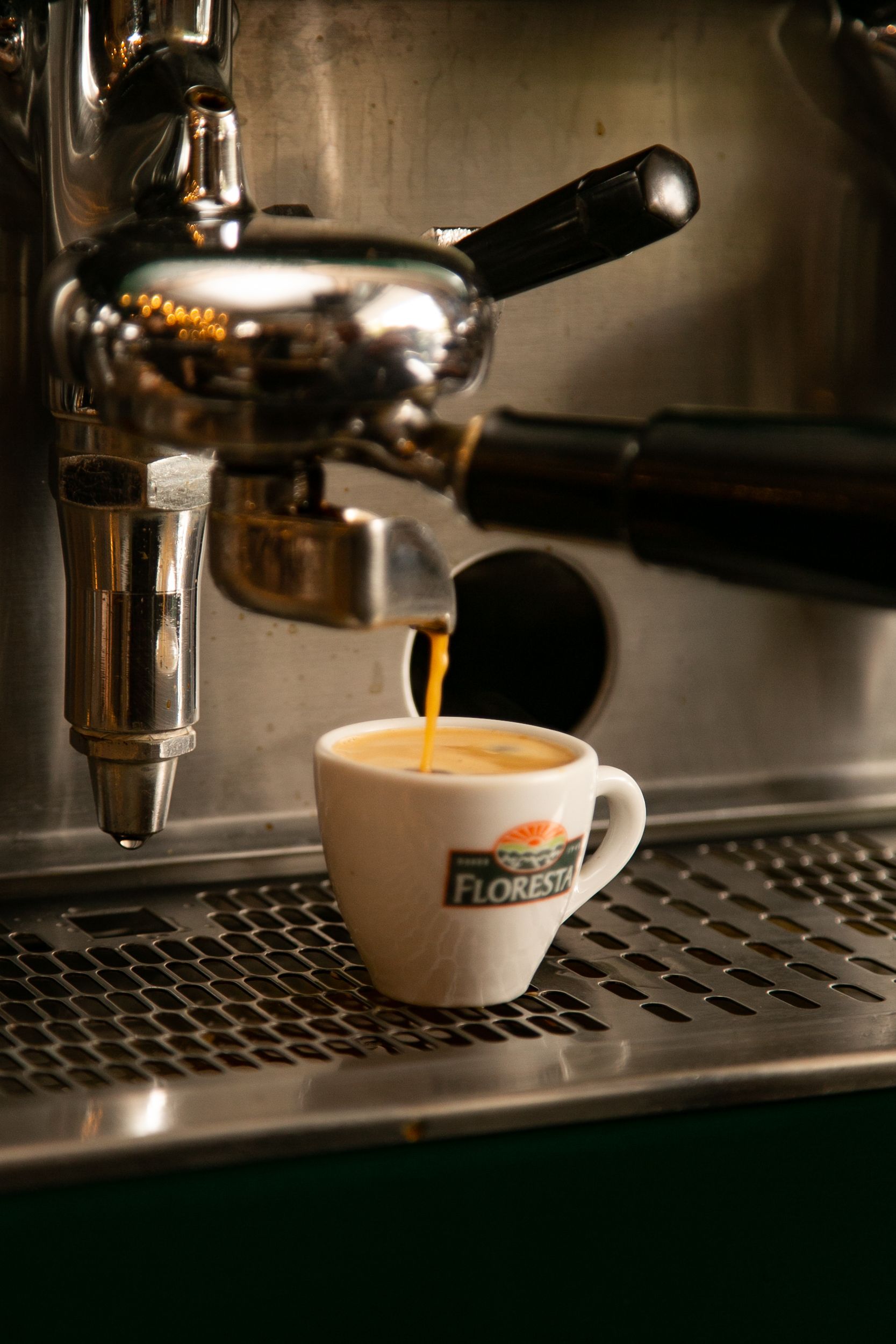 Close-up of espresso pouring from a machine into a cup in a Santos cafe.
