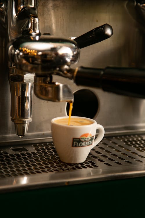 Close-up of Coffee Pouring from a Coffee Machine into a Cup 