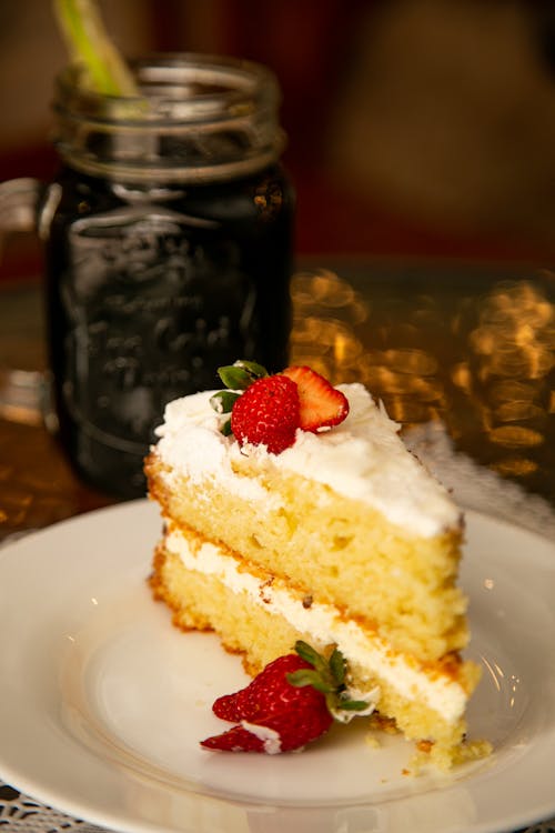 Close-up of a Slice of Cake with Cream and Strawberries 