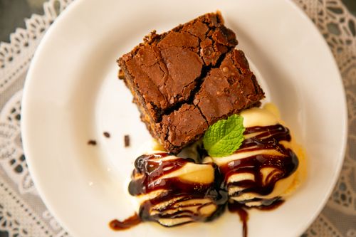 Free Top view of a decadent chocolate brownie served with vanilla ice cream and mint garnish. Stock Photo