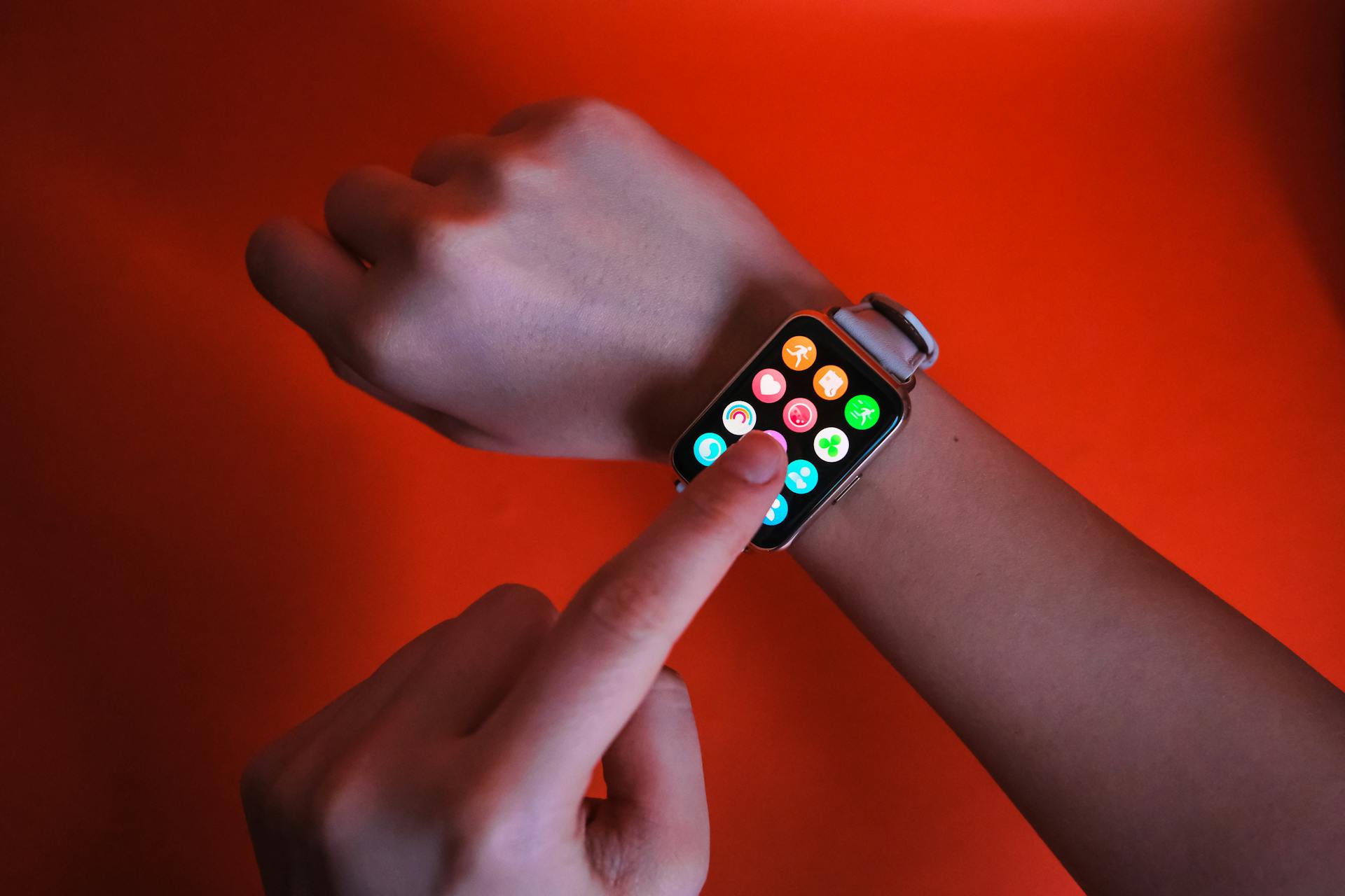 A person interacts with a smartwatch in a vibrant setting, highlighting modern technology.