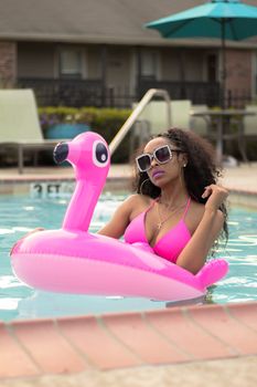 A woman enjoys a sunny day lounging on a pink flamingo pool float in Nashville.