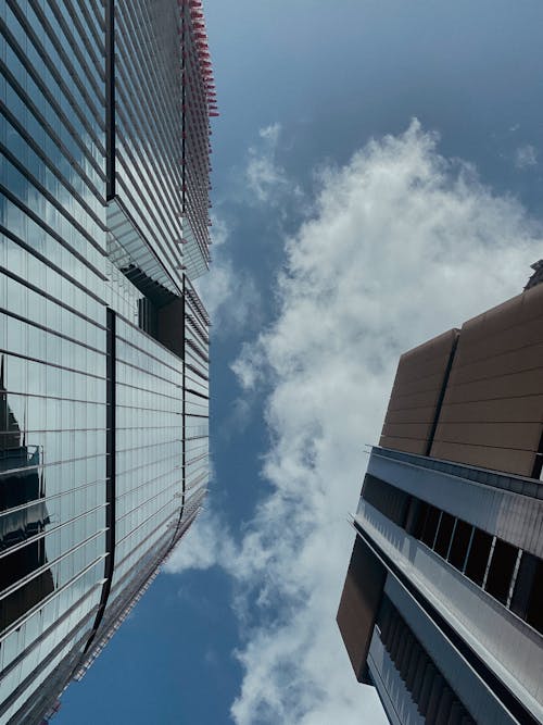 Low Angle Shot of Modern Skyscrapers under Blue Sky with White Clouds 