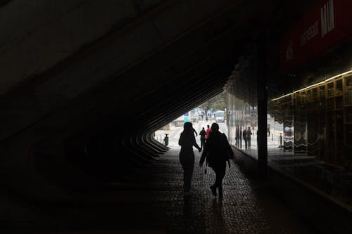 Back View of People Walking through a Tunnel 