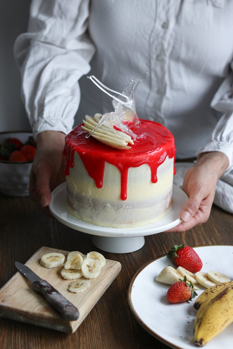 Woman Decorating Birthday Cake At Kitchen