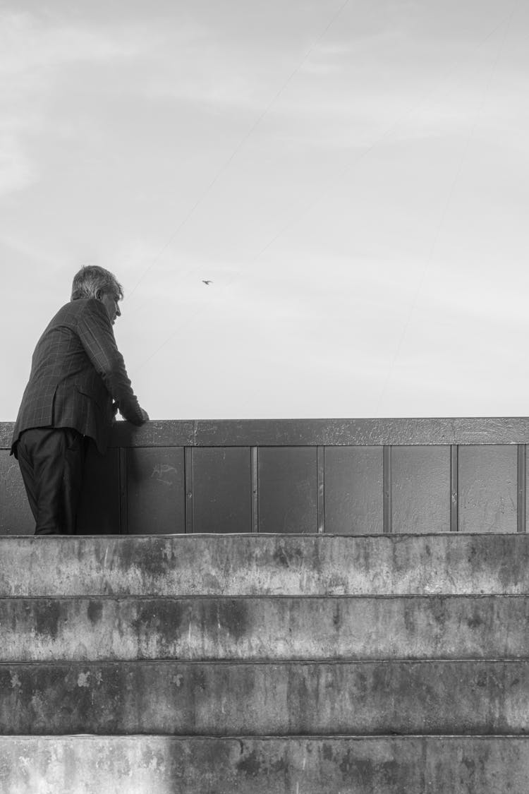 Man In Suit Standing By Wall