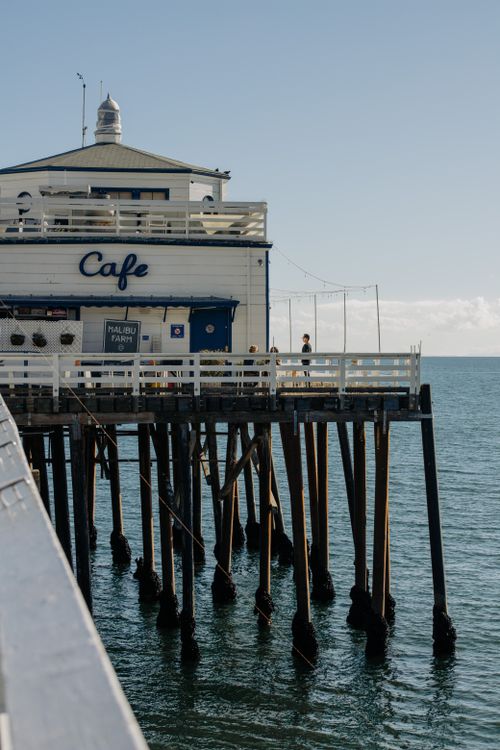 Free A picturesque view of a seaside cafe on the iconic Malibu Pier under a clear sky. Stock Photo