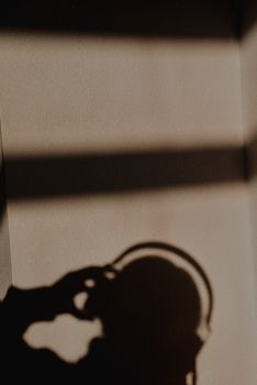 Shadow silhouette of a person wearing headphones, creating a conceptual art effect.