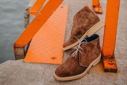Brown suede boots on a harbour wall — photo by Aria Johnson on Pexels