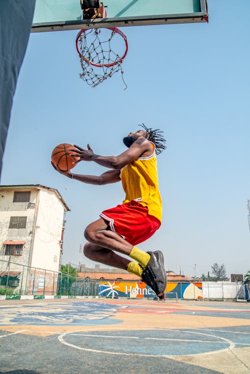 Man Jumping with Ball under Hoop