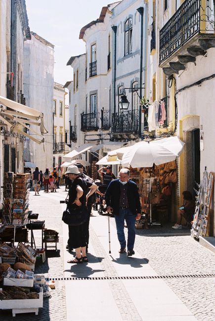 Explore the quaint street market in the historic city of Evora, Portugal, with vibrant stalls and classic architecture.