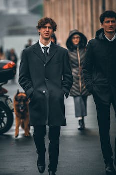 Two well-dressed men in coats walking on a city street in Milan, showcasing fashion in an urban setting.