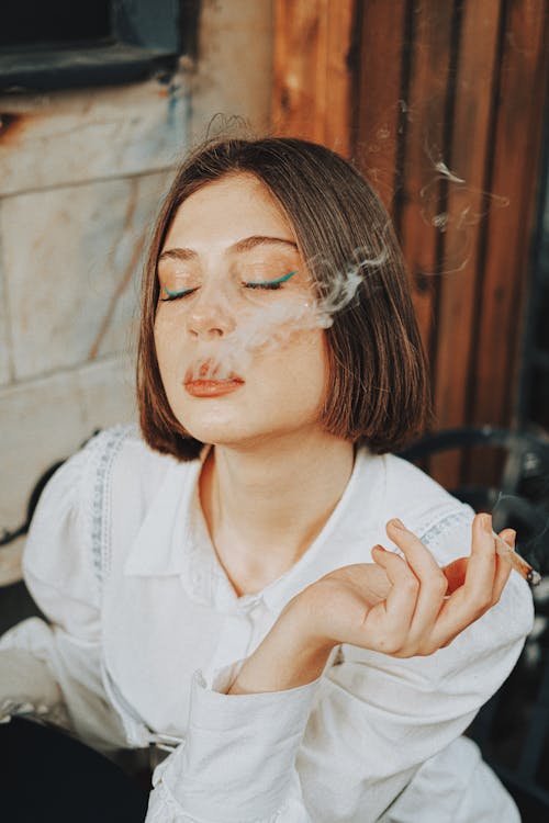 Portrait of a Pretty Brunette Smoking a Cigarette