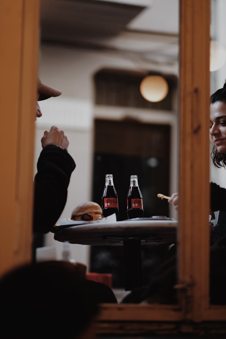 Couple Eating Burgers And Fries With Coca Cola