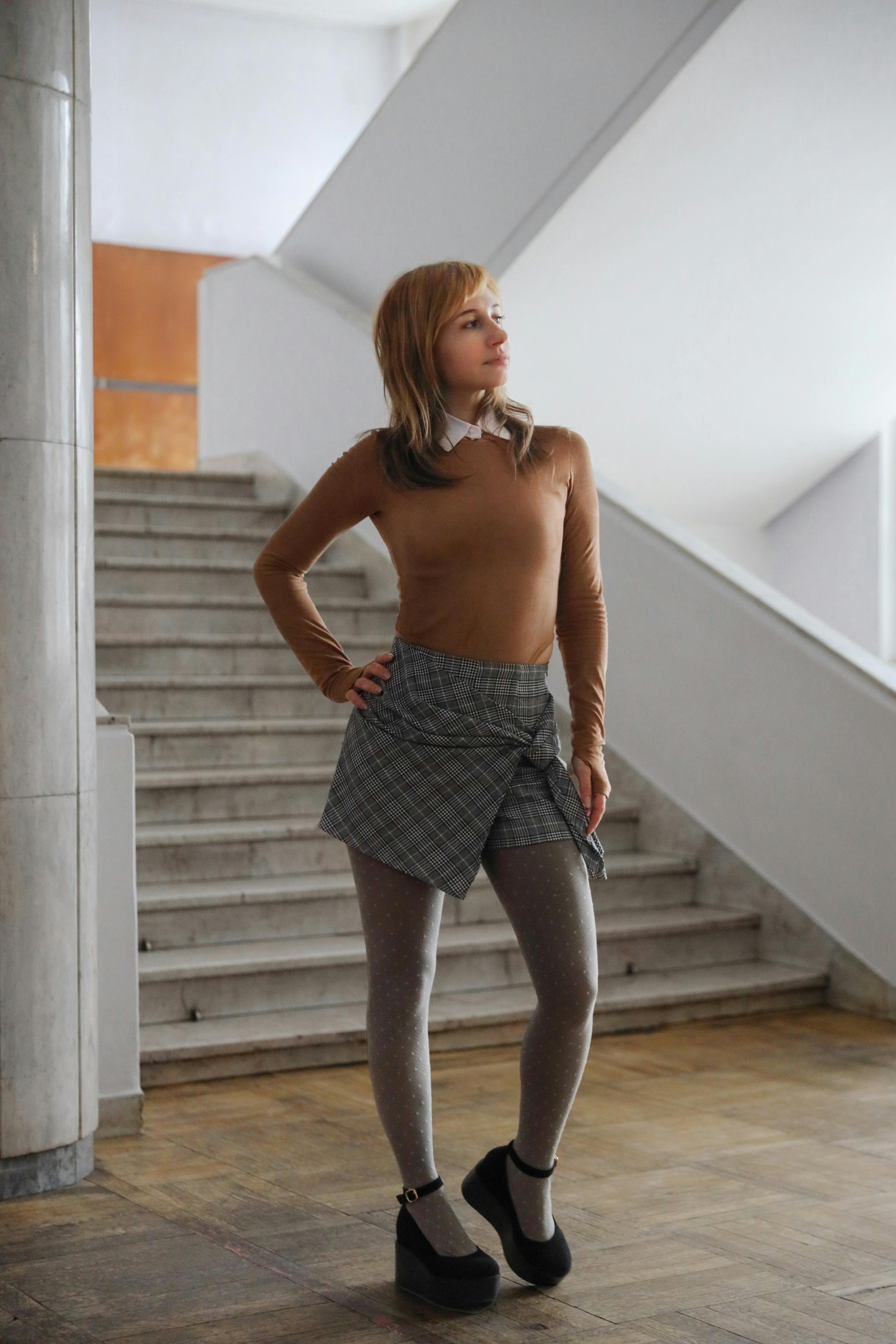 Woman in Checkered Skirt Standing by Stairway · Free Stock Photo