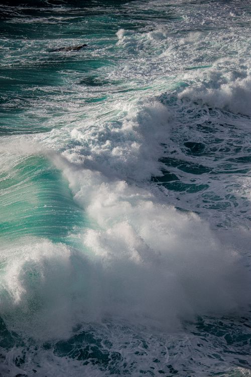 Free A dramatic capture of ocean waves crashing fervently with foam and spray. Stock Photo