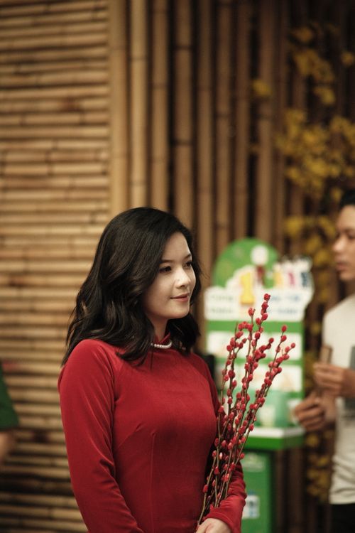Free Portrait of a young woman in a red dress holding flowers at a festival in Hồ Chí Minh. Stock Photo