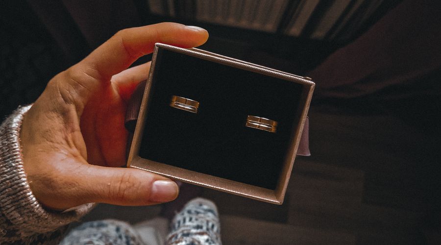 Personne tenant un écrin à bijoux ouvert avec des bagues à l'intérieur