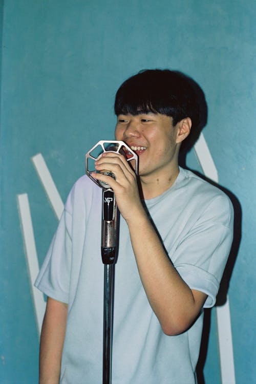 Photo of a Man Singing to a Microphone 