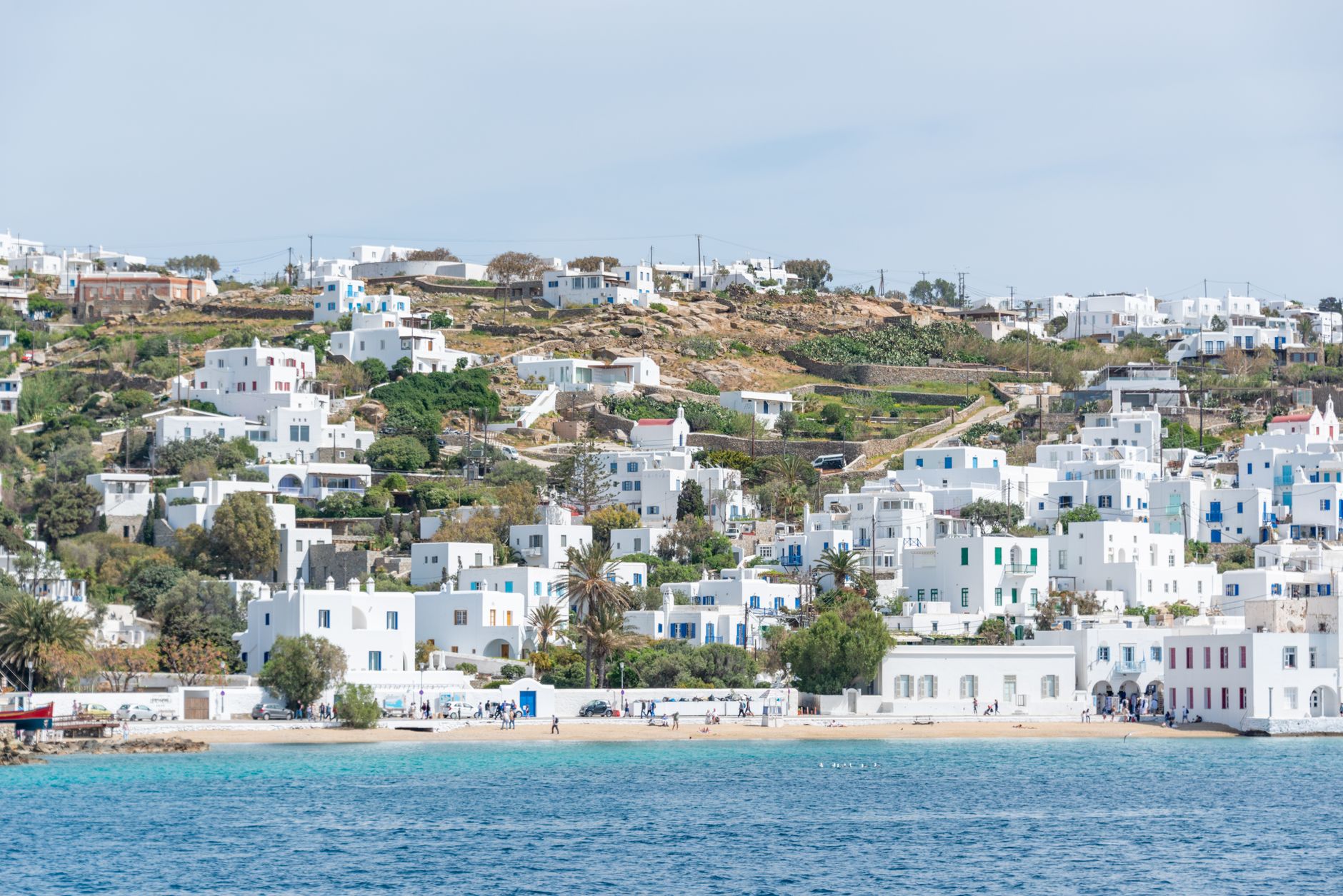 A picturesque coastal town with iconic white Cycladic architecture on a sunny day in Greece.