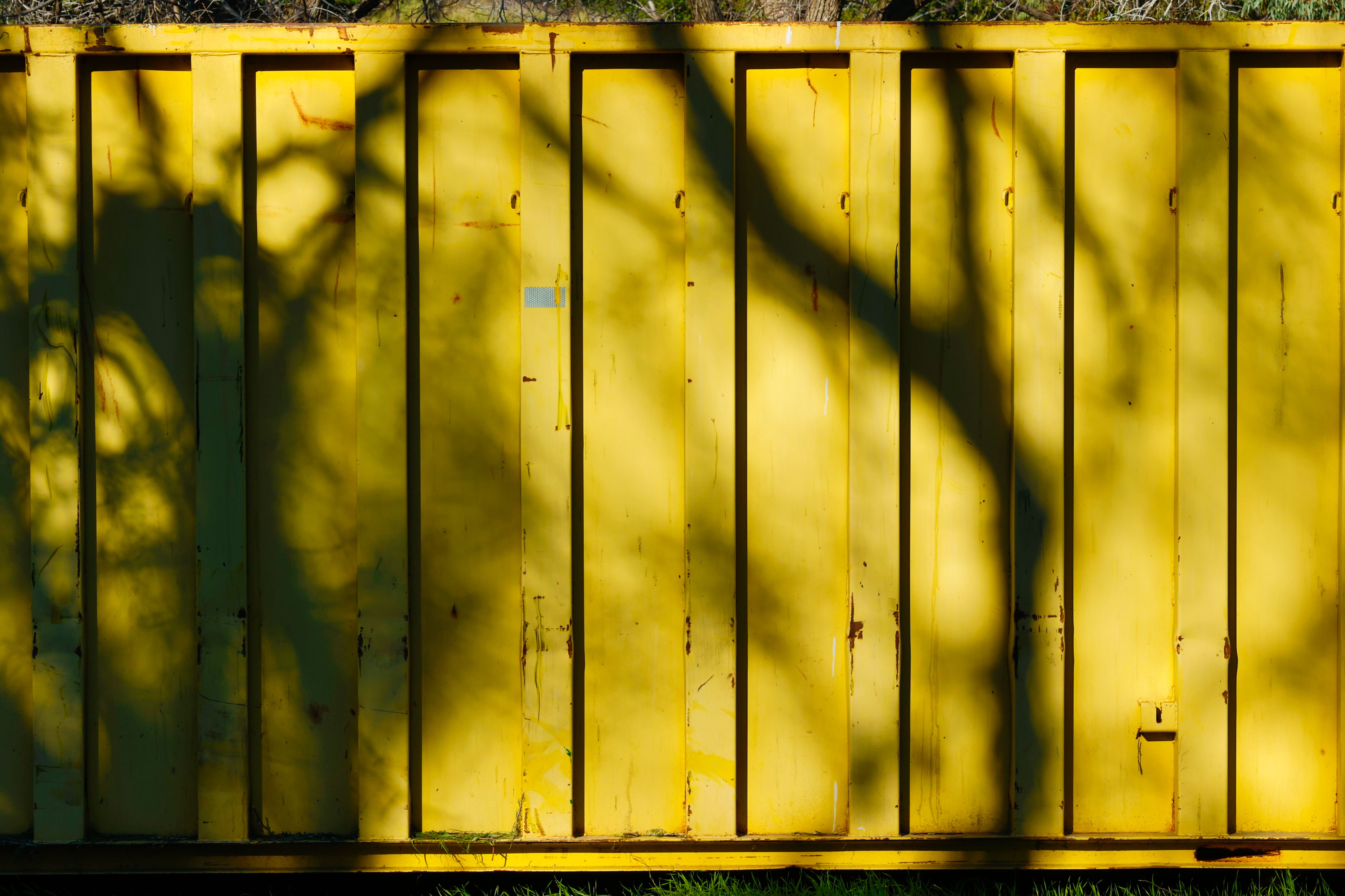 Shadows of Trees on a Yellow Container · Free Stock Photo
