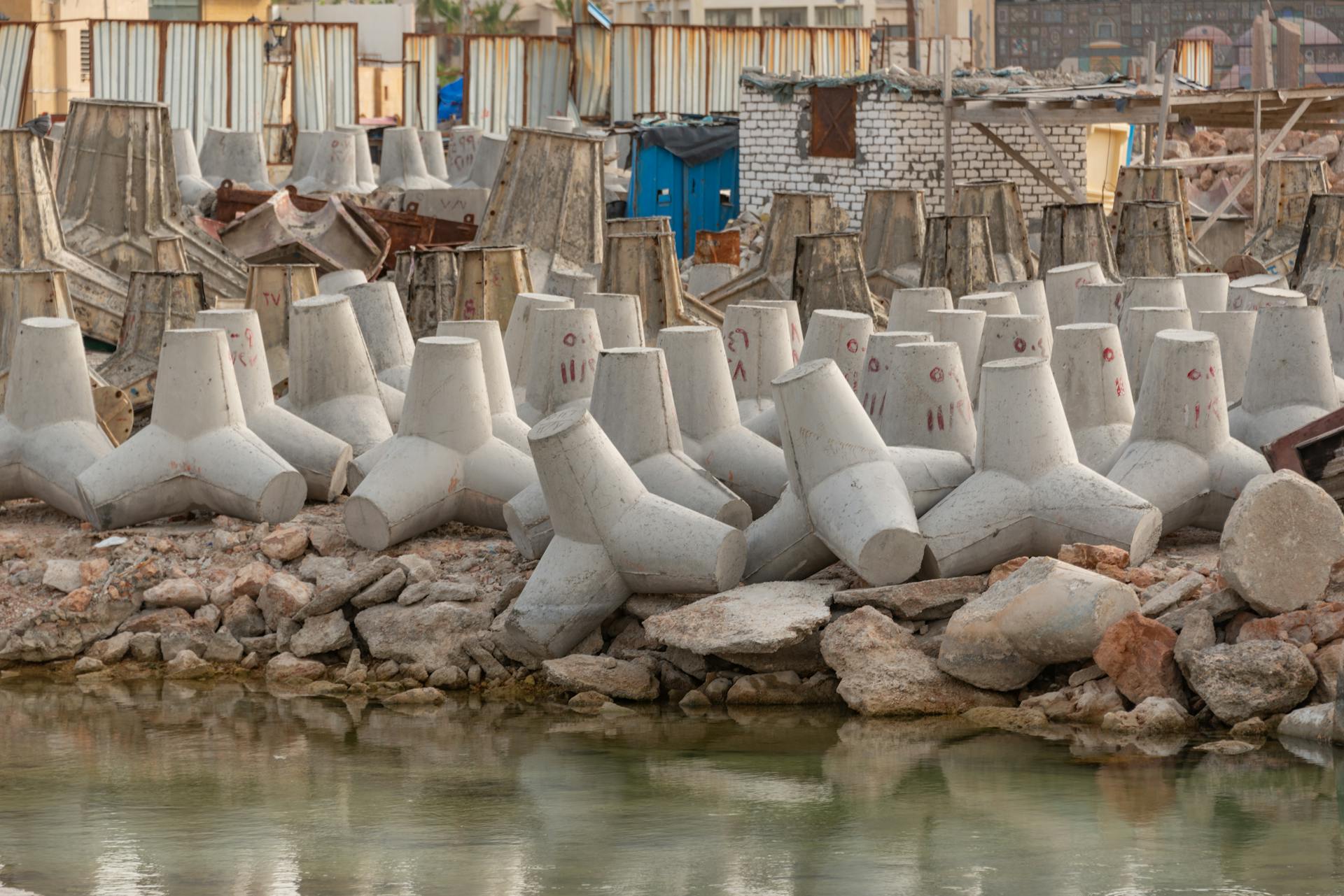 Concrete tetrapods lining the industrial coastline for erosion control and coastal protection.