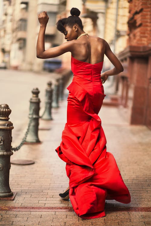 Woman in a Red Dress Posing on the Sidewalk 