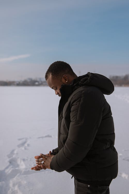 Man Standing in the Field in Winter and Rubbing his Hands