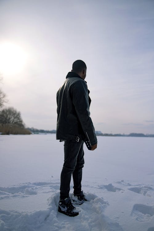 Man Standing in the Snow Covered Field 