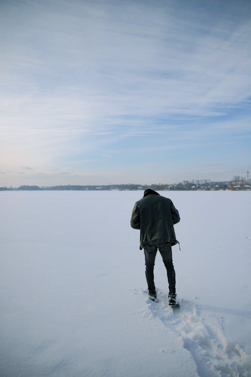 A Man Walking on a Snow Covered Ground