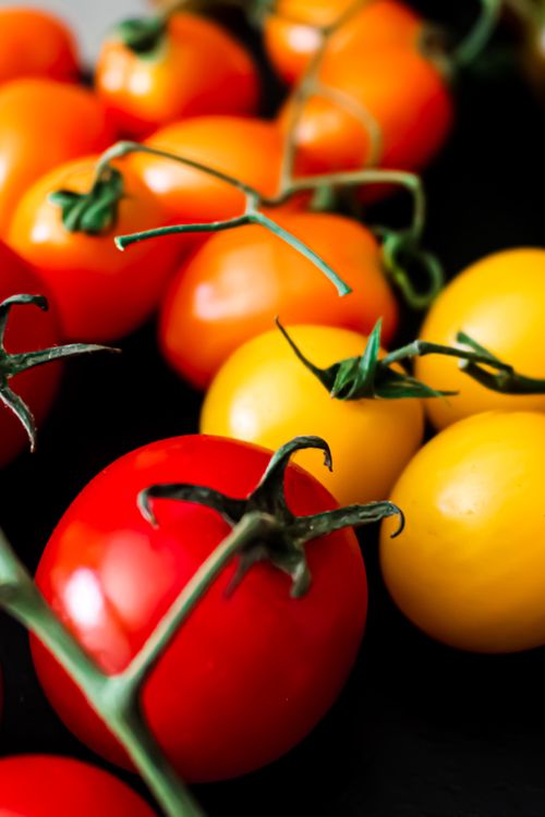 Free Colorful assortment of ripe cherry tomatoes in vibrant colors for a fresh and healthy look. Stock Photo